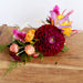 Flower headband with a large purple dahlia and yellow and purple ranunculus and other flowers