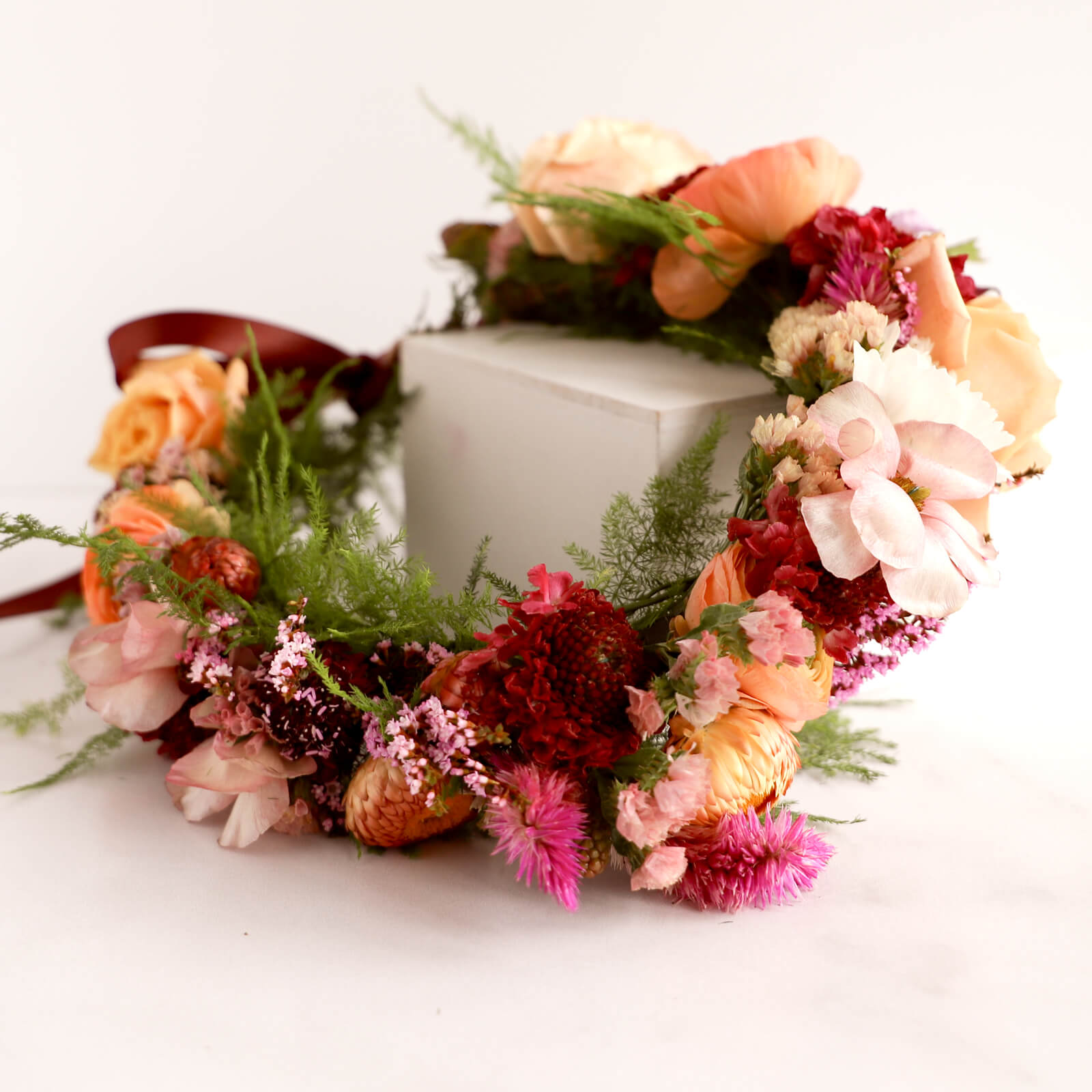 Deluxe floral crown made of pink, purple, orange and peach flowers.